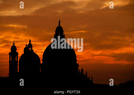 Geheimnisvolle Sonnenuntergang über Salute Basilika (Saint Mary für Gesundheit) alten Kuppeln in Venedig Stockfoto