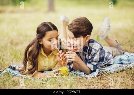 Zwei Kinder Saft trinken zusammen. Stockfoto