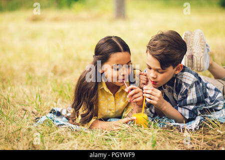 Zwei Kinder Saft trinken zusammen. Stockfoto