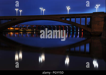 Berwick-upon-Tweed, Großbritannien, Brücken bei Nacht. Royal Tweed Bridge, in der Nähe der Kamera, und die Royal Border Bridge - eine Eisenbahnbrücke - beleuchtet in der Nacht Stockfoto