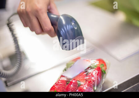 Bar Code Reader lesen Sie den Code eines Pakets von Erdbeeren auf der Kasse in einem Supermarkt Stockfoto