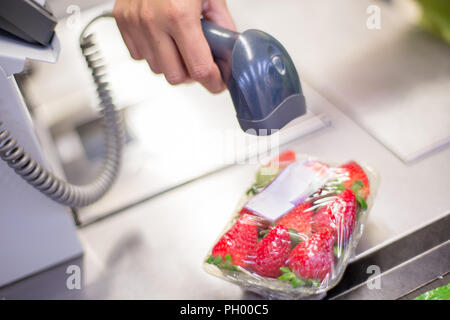 Bar Code Reader lesen Sie den Code eines Pakets von Erdbeeren auf der Kasse in einem Supermarkt Stockfoto