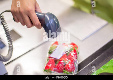 Bar Code Reader lesen Sie den Code eines Pakets von Erdbeeren auf der Kasse in einem Supermarkt Stockfoto