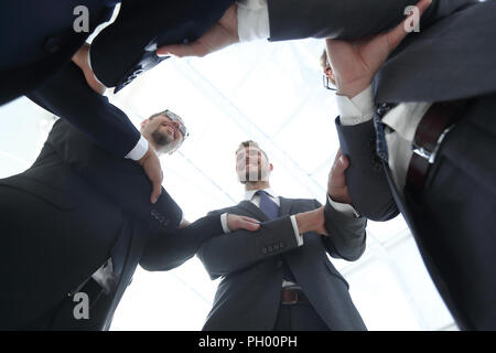 Ansicht von unten. Lächeln Geschäft Leute bilden einen Kreis Stockfoto