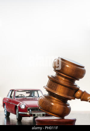 OLDTIMER-AUKTION MGB GT RED Konzeptbild des klassischen roten Jahrgangs 1969 MGB GT mit Auktionatoren Hammer in Oldtimer-Auktionssituation Stockfoto