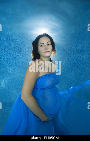 Odessa, Ukraine. 27 Aug, 2018. Schwangere Frau in einem blauen Kleid unter Wasser im Pool Credit Posing: Andrey Nekrasov/ZUMA Draht/Alamy leben Nachrichten Stockfoto