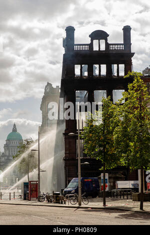 Belfast, UK. 29. August 2018. Mitglieder der Nordirischen Fire and Rescue Service (NIFRS) weiter unten die ausgebrannte Hülle des Primark Store im Zentrum von Belfast zu feucht. Die historische wurde komplett zerstört nach Feuer es Credit: Bonzo/Alamy Leben Nachrichten verschlungen Stockfoto