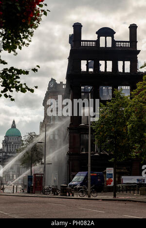 Belfast, UK. 29. August 2018. Mitglieder der Nordirischen Fire and Rescue Service (NIFRS) weiter unten die ausgebrannte Hülle des Primark Store im Zentrum von Belfast zu feucht. Die historische wurde komplett zerstört nach Feuer es Credit: Bonzo/Alamy Leben Nachrichten verschlungen Stockfoto