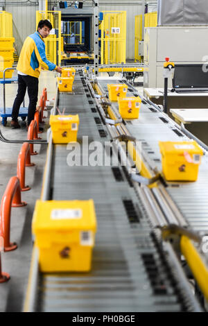 (180829) - Peking, Aug 29, 2018 (Xinhua) - ein Mitarbeiter Arbeitnehmer setzt sharing Express Boxen auf einem Förderband zu einem logistische Basis des e-commerce Riese Suning in Nanjing, der Hauptstadt der ostchinesischen Provinz Jiangsu, Okt. 31, 2017. (Xinhua/Li Bo) Stockfoto