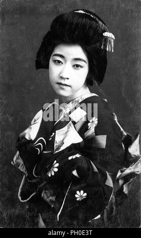 [1920s Japan - Maiko (Lehrling Geisha)] - Junge japanische Maiko (lehrling Geisha) im Kimono und traditionelle Frisur. 20. jahrhundert alte Ansichtskarte. Stockfoto