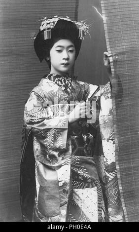 [1920s Japan - Maiko (Lehrling Geisha)] - Junge japanische Maiko (lehrling Geisha) im Kimono und traditionelle Frisur. 20. jahrhundert alte Ansichtskarte. Stockfoto