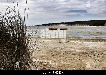 Boote auf Lagoa de Albufeira an einem bewölkten Tag im Frühling Stockfoto