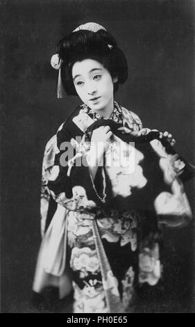 [1920s Japan - Maiko (Lehrling Geisha)] - Junge japanische Maiko (lehrling Geisha) im Kimono und traditionelle Frisur. 20. jahrhundert alte Ansichtskarte. Stockfoto