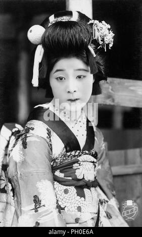 [1920s Japan - Maiko (Lehrling Geisha)] - Junge japanische Maiko (lehrling Geisha) im Kimono und traditionelle Frisur. 20. jahrhundert alte Ansichtskarte. Stockfoto