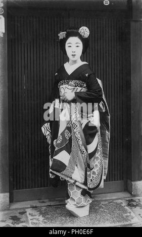 [1920s Japan - Maiko (Lehrling Geisha)] - Junge japanische Maiko (lehrling Geisha) im Kimono und traditionelle Frisur. 20. jahrhundert alte Ansichtskarte. Stockfoto