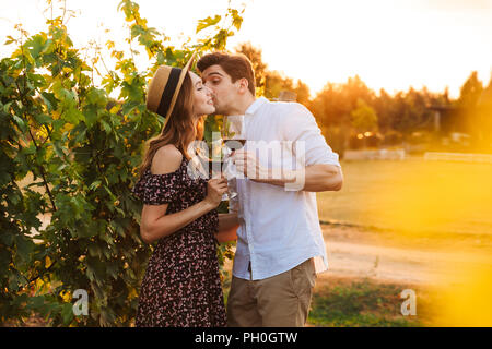 Foto der Jungen niedlich glücklich liebend Paar im Freien, Wein trinken und Küssen. Stockfoto