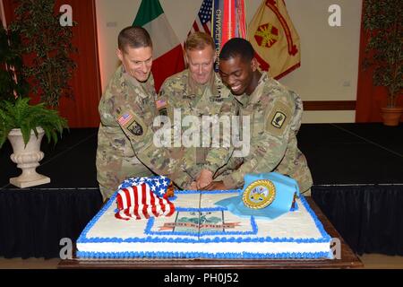 USAG Italien Garrison Commander hilft, die ältesten und jüngsten Soldaten die zeremoniellen Kuchen während der im Geburtstag Feier am Goldenen Löwen, Vicenza, Italien, 14. Juni 2018. Die Veranstaltung wurde von meinem lokalen italienischen Beamten erschienen weitere militärische und zivile Partnerschaften in der Region Venetien Von links: U.S Armee Afrika Oberst Douglas R. Campbell; Garrison Commander Col. Erik M. Berdy und 173Rd Airborne Brigade Pvt stärken. Trentretius L. Robinson. Stockfoto