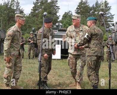 Oberstleutnant Adam Lakai, Battle Group Polen Kommandeur, Generalmajor Jaroslaw Mika, Generalstabschef der Polnischen Streitkräfte, Generalmajor Timothy McGuire, stellvertretender Kommandeur der US-Landstreitkräfte in Europa und Brig. Gen. Jarosław Gromadziński, Kommandant des 15. mechanisierte Brigade geben Eröffnungsrede auf einer Pressekonferenz während der Abschlussveranstaltung von Sabre Streik 18 an der Bemowo Piskie, Polen am 15. Juni 2018. Sabre Streik 18 ist der achte Iteration des langjährigen US-Army Europe - LED-kooperative Ausbildung Übung entwickelt, um die Interoperabilität zwischen Alliierten und regionalen p verbessern Stockfoto