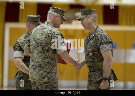 Us Marine Corps Oberst Christian Cabaniss, Mitte, der stellvertretende Kommandeur der 2. Marine Division, II Marine Expeditionary Force, schüttelt Hände mit Oberstleutnant Lance J. Langfeldt, rechts, ausgehende kommandierender Offizier der 2. Tank Battalion, 2nd Marine Division, die während eines Befehls Zeremonie in Camp Lejeune, N.C., 15. Juni 2018. Während der Zeremonie Langfeldt Befehl der Steuereinheit zu Oberstleutnant Charles D. Nicol aufgegeben. Stockfoto