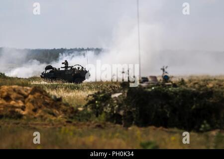 Eine britische Armee Mobilität Weapon-Mounted Installation Kit "Schakal" mit 1 Queen's Dragoon Guards, Brände an Feinde während einer Letalität Demonstration für übung Puma 2 mit Battle Group Polen Bemowo Piskie, Polen am 15. Juni 2018 im Rahmen der Sabre Streik 18. Die diesjährige Übung, die läuft von Juni 3-15, tests Verbündete und Partner aus 19 Ländern auf ihrer Fähigkeit, arbeiten zusammen, um die Aggression in der Region zu verhindern und die Fähigkeit der einzelnen Einheit ihre benannten Mission durchführen zu verbessern. Stockfoto