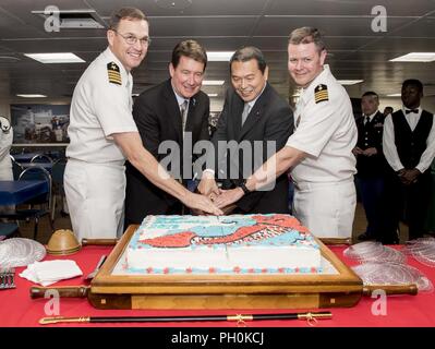 Japan (16. Juni 2018) Kapitän David Bretz (links), mission Commander von Pacific Partnership 2018 (PP18), US-Botschafter in Japan, Herrn Abgeordneten William F. Hagerty IV, Staatsminister für Disaster Management Hachiro Okonogi und Capt John R. Rotruck (rechts), kommandierender Offizier der Military Sealift Command Hospital Ship USNS Mercy (T-AH 19) schnitt ein Stück Kuchen während einer Big Top Empfang an Bord Military Sealift Command Hospital Ship USNS Mercy (T-AH 19). USNS Mercy macht port Besuche in Yokosuka und Tokio Beziehungen zwischen U.S. Navy Segler und japanische Bürger durch kulturellen Austausch fördern und b Stockfoto