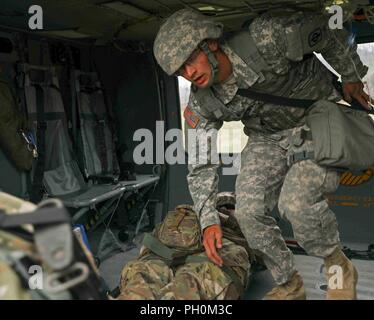 Us-Soldaten der 1077Th medizinische Gesellschaft (Ambulanz), Kansas Army National Guard, Hilfe, Opfer auf ein UH 60 L Blackhawk während der Goldenen Coyote im Custer State Park, S.D., 16. Juni 2018. Die goldenen Coyote Übung ist eine dreiphasige, Szenario-driven Übung in den Black Hills von South Dakota und Wyoming, mit dem Kommandanten auf der Mission wesentliche Anforderungen der Aufgabe, Krieger Aufgaben und Übungen zu konzentrieren. Stockfoto