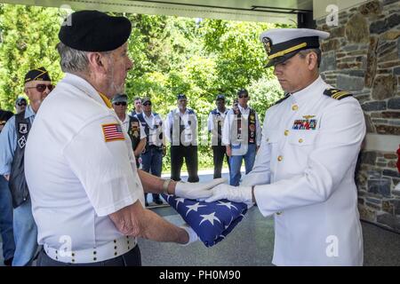 Us Navy Lieutenant Cmdr. Justin Callaghan, rechts, präsentiert die amerikanische Flagge zu Wally Noonan, zeremonielle Vorsitzender, New Jersey Mission der Ehre (NJMOH), während die 28 NJMOH Zeremonie an der Brigadier General William C. Doyle Veterans Memorial Friedhof im Norden Hannovers Township, New Jersey, 14. Juni 2018. Die cremains von sieben Weltkriegveterane Geoffrey N. Barrow, Henry Brandon und Frau, Willa Mae; Arthur R. Callan, James Grant Sr., Theodore R. Jackson jr., Monroe E. Morris, und Charlie Waters; zwei Vietnam Veteranen Johnny W. Morgan und Gilbert J. Shelton, und eine Ära des Kalten Krieges veteran Leland D. Bey, wir Stockfoto