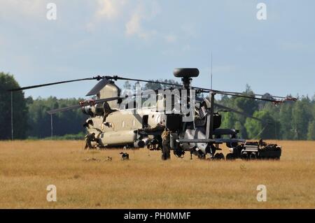 Us-Soldaten zum 12 Combat Aviation Brigade zugeordnet führt die Wartung eines AH-64 Apache Helikopter und einem CH-47 Chinook Hubschrauber während Sabre Strike18 am Bemowo Piskie Training Area in Orzysz, Polen, 14. Juni 2018. Stockfoto