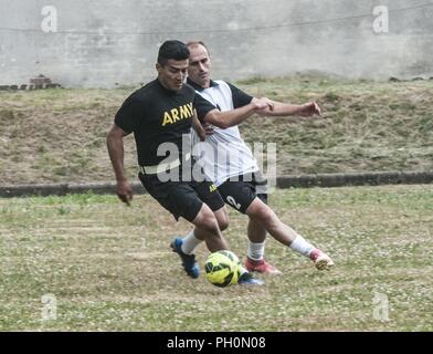 Ein US-Soldat in die 91St Ingenieur Bataillon zugeordnet, 1. gepanzerte Brigade Combat Team, 1 Calvary Division Blöcke, die Fußball von seinem 23 Artillery Brigade, polnisches Land Kräfte Gegner während einer Fußball-Spiel zum Gedenken an den im Armee Geburtstagsfeier im polnischen Land Forces Base in Boleslawiec, Polen, 14. Juni 2018 statt. Die gemeinsame Feier inklusive einer Basis-weit laufen, Veranstaltungen und einen Kuchen Cutting. Stockfoto