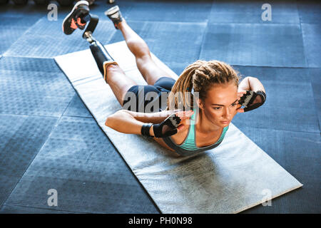 Bild der erstaunlich starke Behindertensport Frau machen sportliche Übungen in der Turnhalle. Stockfoto