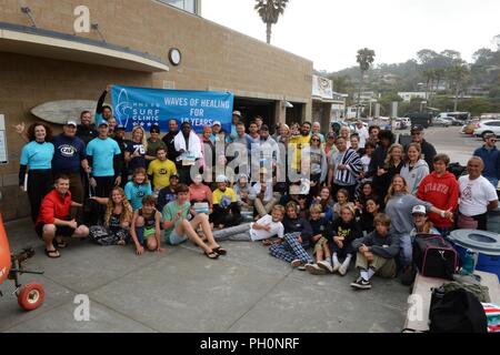 DEL MAR, Kalifornien (14. Juni 2018) Naval Medical Center San Diego (NMCSD) Surf Klinik Mitarbeiter und Freiwilligen zusammen mit Studenten aus der Surf Academy in Santa Monica posieren für ein Gruppenfoto in der Feier des 10. Jahrestages des Surf Klinik. Die Surf Klinik ist vom Gesundheits- und Wellness- Abteilung koordiniert, Verwundete, Kranke zu rehabilitieren, und verletzten Service Mitglieder durch Übung und entspannende Therapie zur Verbesserung ihrer körperlichen, geistigen und sozialen Wohlbefindens. Stockfoto