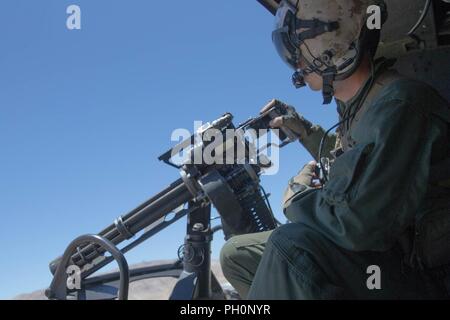 Staff Sgt. Andrew Weanie, einen Hubschrauber Crew Chief mit Marine Light Attack Helicopter Squadron 775, Marine Flugzeuge Gruppe 41, 4 Marine Flugzeugflügel, beobachtet die erworbenen Ziele während einer Schließung air support Mission, während integrierte Ausbildung Übung 4-18 bei Marine Corps Air Ground Combat Center Twentynine Palms, Calif., 18. Juni 2018. HMLA-775, auch bekannt als "kojoten", vorausgesetzt Air Combat element Unterstützung für Marine Air Ground Task Force 23 während ITX 4-18. Stockfoto