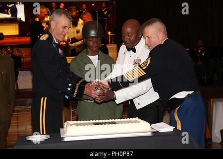 Pfc. Cynarra Strickland, 35th Combat Sustainment Unterstützung Bataillon zugeordnet, beteiligt sich an der Kuchen- Zeremonie, während die Kugel für im Armee Geburtstag im Camp Zama Gemeinschaft Club Juni 14, 2018 zusammen mit Generalmajor James F. Pasquarette, Links, kommandierender General der US-Armee in Japan, und Command Sgt. Maj Richard Clark, rechts, command Sergeant Major von USARJ. Stockfoto