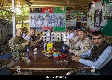 Der Provinz Helmand, Afghanistan (16. Juni 2018) - U.S. Marines und US-Armee Soldaten mit Task Force (Südwest) (TFSW) und der afghanischen Armee (ANA) 215 Corps Soldaten ein Toast Eid al-Fitr im Camp Shorabak zu feiern geben. ANA Soldaten eingeladen, US-Mitglieder mit TFSW in einer der wichtigsten religiösen Feiertage im Islam, Eid al-Fitr, das den Abschluss von etwa 30 Tagen von Dawn feiert - bis abends Fasten im Ramadan zu teilen. Stockfoto