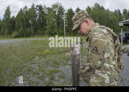Us-Armee Sgt. Christian W. Calame auf das erste Bataillon zugeordnet, 4 Infanterie Regiment, 7th Army Training Command (7 ATC) prüft seinen Kompass Azimut vor der Navigation während der 7 ATC-besten Krieger Wettbewerb, Grafenwöhr Training Area, Deutschland, 19. Juni 2018. Die dreitägige Veranstaltung endet am 21. Juni mit der Ankündigung des 7. ATC-Officer, noncommissioned Officer und Soldat des Jahres. Die Gewinner werden am Bewegen in der US-Armee in Europa am besten Krieger Wettbewerb zu konkurrieren. Stockfoto