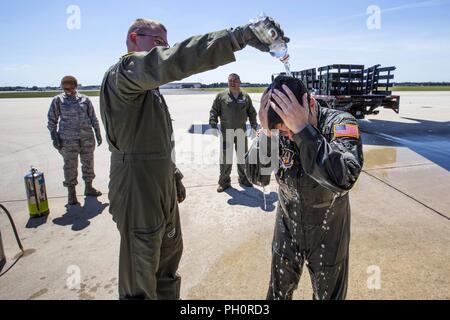 Us Air Force flugkrankenschwester Kapitän Robert E. Holland, Links, gießt Wasser auf Senior Master Sgt. Jennifer R. Mose, Mitte, 514Th senior Flight Examiner und noncommissioned Officer für die Einhaltung der Standards und Bewertungen, sowohl mit der 514Th Aeromedical Evacuation Squadron, 514Th Air Mobility Wing, nach Ihrer letzten Flug bei Joint Base Mc Guire-Dix - Lakehurst, New Jersey, 17. Juni 2018. Der letzte Flug, oder Fini - Flug, ist eine Tradition unter Air Crew den letzten Flug mit ihrer Einheit zu feiern, oder auf eine bestimmte Zelle. Die 514Th ist ein Air Force Reserve Command unit. Stockfoto