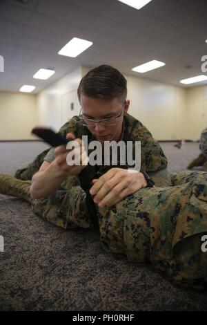 Sgt. Marcus Dekan, ein Data System Administrator mit Sitz Regiment, 3. Marine Logistik Gruppe, gilt ein stauschlauch während der Schlacht Fähigkeiten Test Juni 21, 2018, am Lager Kinser, Okinawa, Japan. Während des CEST, Marines sind auf verschiedene Fähigkeiten wie ein Radio, Anwendung Blutsperregeräte und Umgang mit Gefangenen getestet. Dean ist ein Eingeborener von Zinnoberrot, Ohio. Stockfoto