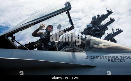 PHILLIPPINE MEER (15. Juni 2018) Aviation Support Equipment Techniker 3. Klasse Hector Orozco, aus Rio Rico, Ariz., Reinigungstücher, den Baldachin auf eine F/A-18E Super Hornet zu Strike Fighter Squadron (VFA) 115 auf dem Flugdeck der Marine vorwärts - bereitgestellt Flugzeugträger USS Ronald Reagan (CVN 76). Ronald Reagan, das Flaggschiff der Carrier Strike Group 5, bietet eine Bekämpfung bereit, Kraft, schützt und verteidigt die kollektive maritime Interessen seiner Verbündeten und Partnern in der indopazifischen Region. Stockfoto