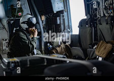 Us Marine Lance Cpl. John C. Delapp, Ein CH-53E Super Stallion Hubschrauber Crew Chief mit speziellen Zweck Marine Air-Ground Task Force - Southern Command, die Gelegenheit nutzt, einen Snack Mitte - Flug in der Nähe von Guatemala City, Guatemala, 21. Juni 2018 zu genießen. Führer mit SPMAGT-SC besucht Marinesoldaten und Matrosen in Puerto Barrios und Flores, Guatemala, Zubehör zu liefern und auf das Wohlergehen der Truppen prüfen. Die Marinesoldaten und Matrosen von SPMAGTF - SC sind die Zusammenarbeit im Bereich Sicherheit Training und Engineering Projekte Neben partner Nation militärischen Kräfte in Zentral- und Südamerika. Das Gerät ist auch Stockfoto