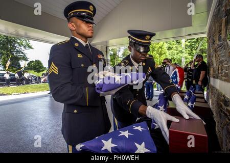 Us-Armee Sgt. Raheem Rowell, rechts, legt eine Urne mit den cremains eines Veterans als Sgt. Segne Sherrill, sowohl mit den New-jersey Army National Guard, hält eine amerikanische Flagge während der 29 New Jersey Mission der Ehre (NJMOH) Zeremonie an der Brigadier General William C. Doyle Veterans Memorial Friedhof im Norden Hannovers Township, New Jersey, 21. Juni 2018. Die cremains von eine Welt krieg ich Veteran Joseph S. Bey, zwei Weltkriegveterane Arthur L. Hodges und James C. Warren, zwei Korean War Veterans Wilbur J. durchbohren und Claude Robinson, drei Vietnam Veteranen Joseph F. Boone jr., Malachia Ric Stockfoto