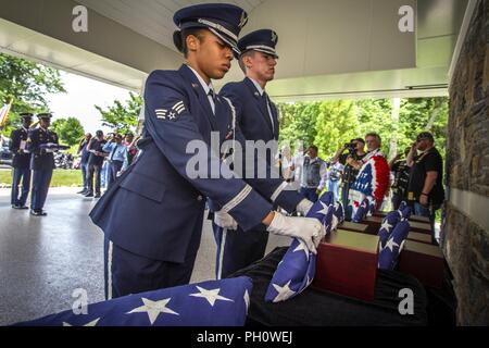 Us Air Force Senior Airman Seetha Dockery, Links, eine Flagge vor eine Urne mit den cremains eines Veterans als Senior Airman Eric Re Guerrero steht an Aufmerksamkeit während der 29 New Jersey Mission der Ehre (NJMOH) Zeremonie an der Brigadier General William C. Doyle Veterans Memorial Friedhof im Norden Hannovers Township, New Jersey, 21. Juni 2018. Die cremains von eine Welt krieg ich Veteran Joseph S. Bey, zwei Weltkriegveterane Arthur L. Hodges und James C. Warren, zwei Korean War Veterans Wilbur J. durchbohren und Claude Robinson, drei Vietnam Veteranen Joseph F. Boone jr., Malachia Rich jr., Stockfoto