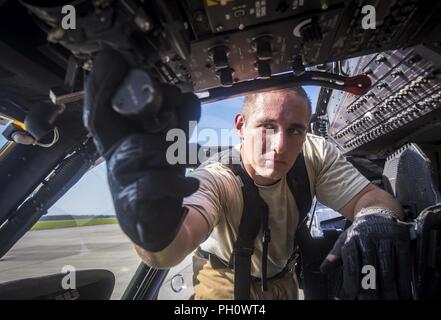 Staff Sgt. Matthäus Montville, 23d Bauingenieur Squadron (CES) Feuerwehrmann, zieht sich zurück, die drosselklappe von einem HH-60G Pave Hawk bei Abschluss eines simulierten Rettung Ausbildung Szenario, 19. Juni 2018, bei Moody Air Force Base, Ga 23d CES Feuerwehrmänner der Ausbildung ihre Kenntnisse und der Vorbereitung von, wie man richtig abschalten und Rescue Crew Mitglieder aus einer HH-60 zu bewerten. Stockfoto