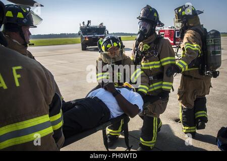 Feuerwehrmänner vom 23 d Bauingenieur Squadron (CES), sichere Charlie Johnson, 23d CES Assistant flight Chief, während ein HH-60G Pave Hawk simulierten Rettung Ausbildung Szenario, 20. Juni 2018, bei Moody Air Force Base, Ga 23d CES Feuerwehrmänner die Ausbildung ihrer Kenntnisse und der Vorbereitung von, wie man richtig abschalten und Rescue Crew Mitglieder aus einer HH-60 zu bewerten. Stockfoto