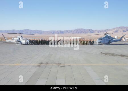 Marines mit Marine Leichter Hubschrauber Attack Squadron 775, Marine Flugzeuge Gruppe 41, 4 Marine Flugzeugflügel, für ein Gruppenfoto der nächsten AH-1W SuperCobra (links) und ein UH-1Y Venom (rechts), während integrierte Ausbildung Übung 4-18 bei Marine Corps Air Ground Combat Center Twentynine Palms, Calif., 21. Juni 2018 dar. HMLA-775, auch bekannt als "kojoten", vorausgesetzt Air Combat element Unterstützung für Marine Air Ground Task Force 23 während ITX 4-18. Stockfoto