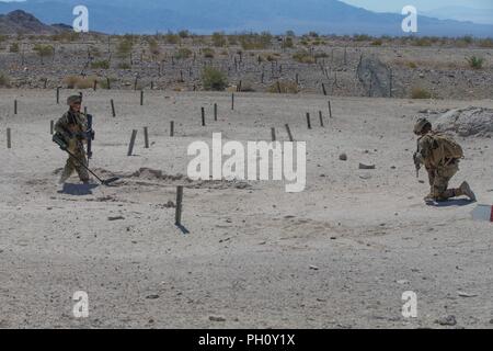 Ein Marine Minesweeper mit 1St Bataillon, 25 Marine Regiment, 4 Marine Division, ebnet den Weg für die Infanterie Unternehmen auf Palette 400, einen Overhead Feuer Infanterie unternehmen Training Strecke, während integrierte Ausbildung Übung 4-18 bei Marine Corps Air Ground Combat Center Twentynine Palms, Calif., 20. Juni 2018. Bereich 400 ist durch Marine Air Ground Task Force 23 verwendet Gewehr Unternehmen in der Techniken und Verfahren für die Angreifenden befestigten Bereichen auszubilden, und ist eine der dynamischsten live - Feuer in der Marine Corps. Stockfoto