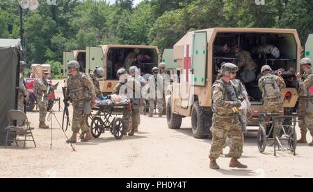 Us-Armee Reservisten mit 865Th Combat Support Hospital in Utica, New York, sind Offloading simuliert, verletzte Soldaten und die Durchführung der Triage als Teil einer Masse Unfallversicherung Übung während der Regionalen Medic CSTX 86-18-04, taktische Schulung Base Gerechtigkeit auf Fort McCoy, Wisc., 23. Juni 2018. CSTX 86-18-04 ist ein Kampf Support Training übung, die sicherstellt, dass America's Army Reserve Einheiten und Soldaten ausgebildet sind und bereit, auf kurze bereitstellen - Bekanntmachung und fähig, Bekämpfung bereit, und tödlichen Feuerkraft zur Unterstützung der Armee und unsere gemeinsamen Partner überall in der Welt. Us-Armee finden Stockfoto