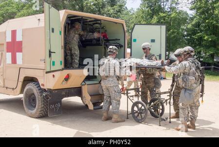 Us-Armee Reservisten mit 865Th Combat Support Hospital in Utica, New York, sind Offloading simuliert, verletzte Soldaten und die Durchführung der Triage als Teil einer Masse Unfallversicherung Übung während der Regionalen Medic CSTX 86-18-04, taktische Schulung Base Gerechtigkeit auf Fort McCoy, Wisc., 23. Juni 2018. CSTX 86-18-04 ist ein Kampf Support Training übung, die sicherstellt, dass America's Army Reserve Einheiten und Soldaten ausgebildet sind und bereit, auf kurze bereitstellen - Bekanntmachung und fähig, Bekämpfung bereit, und tödlichen Feuerkraft zur Unterstützung der Armee und unsere gemeinsamen Partner überall in der Welt. Us-Armee finden Stockfoto