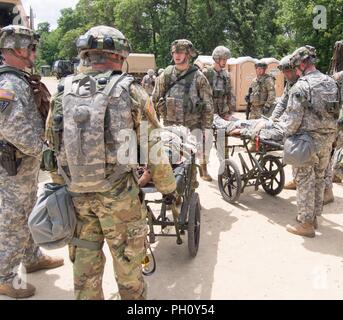 Us-Armee Reservisten mit 865Th Combat Support Hospital in Utica, New York, sind Offloading simuliert, verletzte Soldaten und die Durchführung der Triage als Teil einer Masse Unfallversicherung Übung während der Regionalen Medic CSTX 86-18-04, taktische Schulung Base Gerechtigkeit auf Fort McCoy, Wisc., 23. Juni 2018. CSTX 86-18-04 ist ein Kampf Support Training übung, die sicherstellt, dass America's Army Reserve Einheiten und Soldaten ausgebildet sind und bereit, auf kurze bereitstellen - Bekanntmachung und fähig, Bekämpfung bereit, und tödlichen Feuerkraft zur Unterstützung der Armee und unsere gemeinsamen Partner überall in der Welt. Us-Armee finden Stockfoto