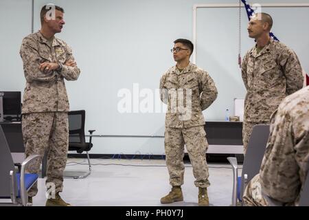 Unbekannten ORT, NAHER OSTEN - US Marine Corps Generalleutnant William D. Beydler (links), der Kommandant der US Marine Corps Forces Central Command (MARCENT), Adressen Münze Empfänger Cpl. Noah A. Pascual (Mitte), ein Maintenance Management Specialist, neben seinem Mentor, Gunnery Sgt. Thomas Rogato (rechts), Leiter der Instandhaltung der Bekämpfung der Logistik Abteilung 37, während ein Town Hall Meeting mit speziellen Zweck Marine Air-Ground Task Force, Krise Response-Central Befehl Juni 22., 2018. Bei seinem Besuch, Beydler anerkannten fünf Marines für Exzellenz in ihren Pflichten und ermutigte die Marines zu Stockfoto