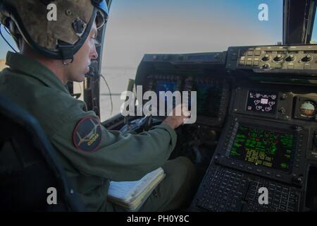 Sgt. Curtis Anglin, ein tiltrotor Crew Chief mit Marine Medium Tiltrotor Squadron 764, Marine Flugzeuge Gruppe 41, 4 Marine Flugzeugflügel, führt Preflight Inspektionen und den Motor laufen lassen, bevor eine Antenne Angriff, während integrierte Ausbildung Übung 4-18 bei Marine Corps Air Ground Combat Center Twentynine Palms, Calif., 23. Juni 2018. VMM-764, wie "Moonlight" bekannt, ist aus der Marine Corps Air Station Miramar und Air Combat element Unterstützung bei ITX 4-18 zu Marine Air Ground Task Force 23. Stockfoto